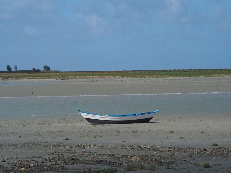 A boat is stranded on the mud flats