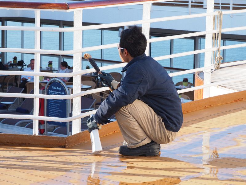 A crew member cleans the railings