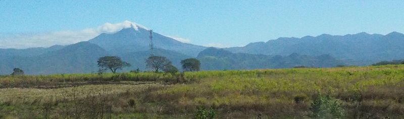 A volcano smolders in the distance