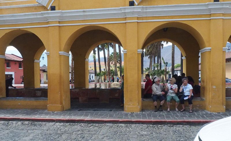 People sitting by a public fountain