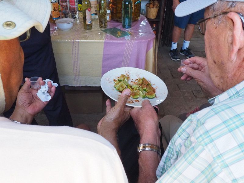 A shot of mezcal followed by a slice of lime with spicy seasonings