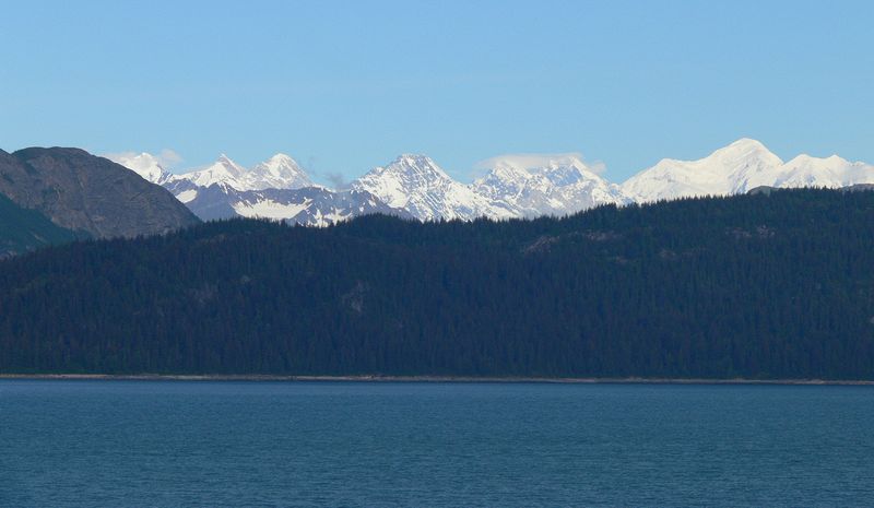 Snow covered mountains peek above the nearby hills