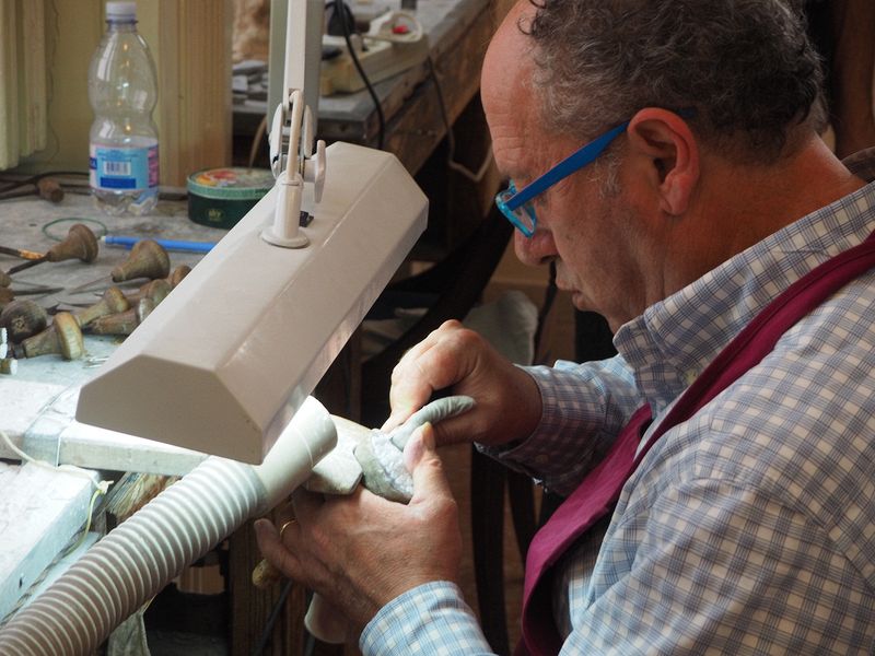 A craftsman making a cameo from a shell
