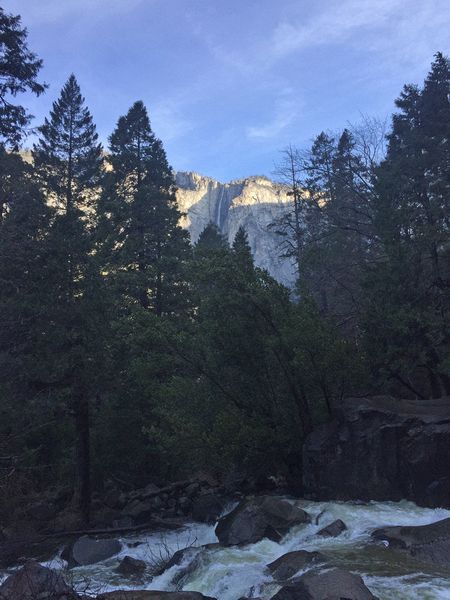 A rushing stream and a high waterfall on the cliff