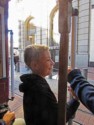 Nicholas stands on the outside of the cable car