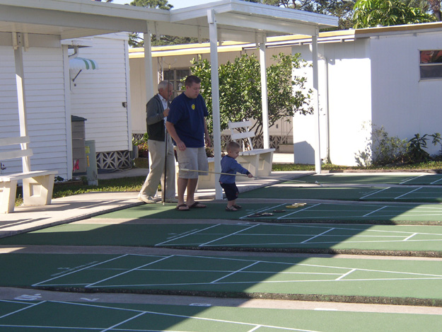 44-GGPa and Dave teach Andrew how to play shuffleboard.  Andrew did well