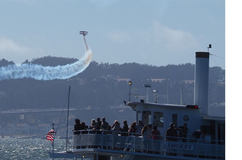 Spectagors watch the biplane from another boat