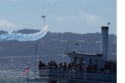 Spectagors watch the biplane from another boat
