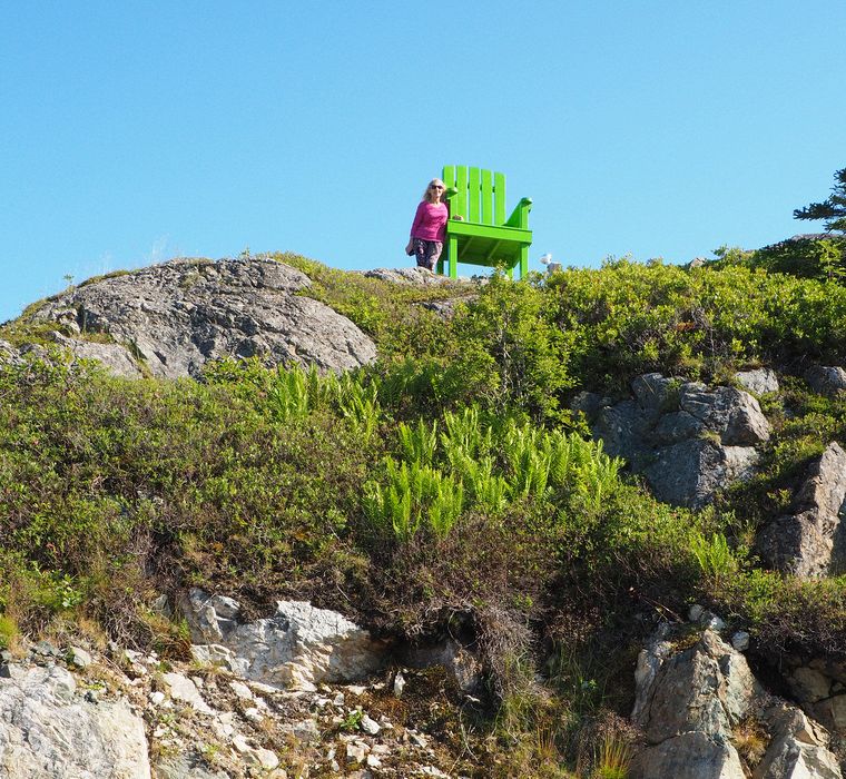 Eloise next to a large decorative chair on a cliff