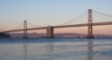Bay Bridge at sunset with a ferry going by