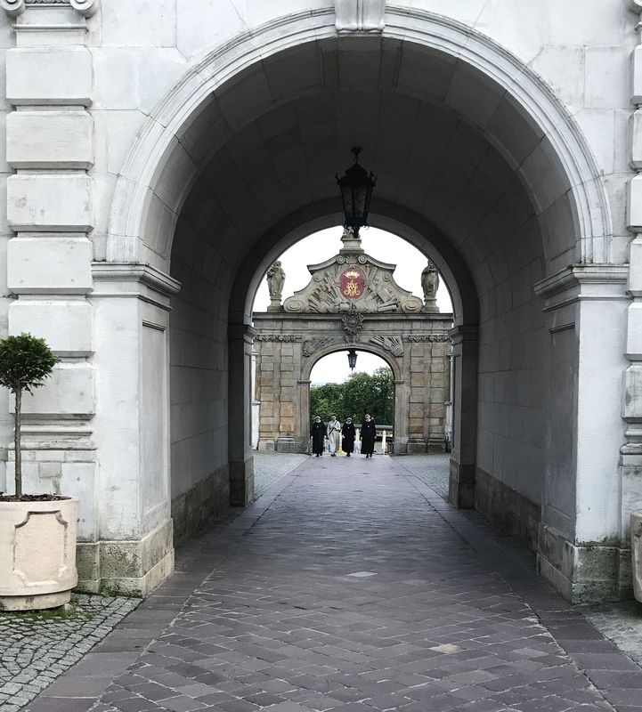 Nuns walking through archways