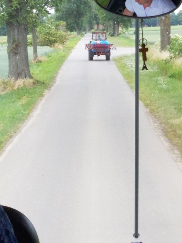 The road is too narrow for the bus and this farm equipment